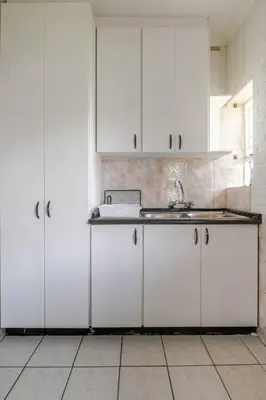 a kitchen with white cabinets and a sink at Inspire living home in Kempton Park