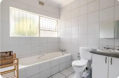 a white bathroom with a tub and a toilet and a sink at Inspire living home in Kempton Park