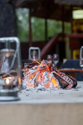 a fire on a table with two wine glasses at Lion Tree Top Lodge in Guernsey Nature Reserve