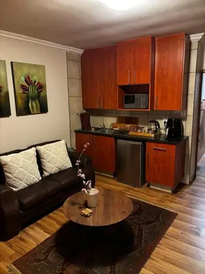 a living room with a couch and a table at Olivestay at Olympus - Apartment in Pretoria