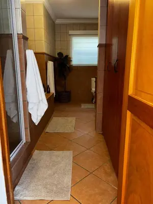 a bathroom with a shower and a toilet with mats at Olivestay at Olympus - Apartment in Pretoria