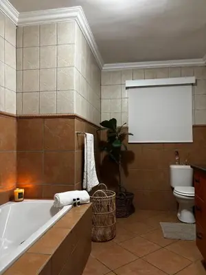 a bathroom with a bath tub and a toilet at Olivestay at Olympus - Apartment in Pretoria