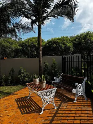a bench and a table and a palm tree at Olivestay at Olympus - Apartment in Pretoria