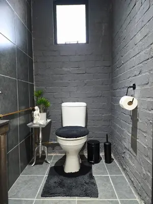 a bathroom with a white toilet and a window at The View in Pretoria