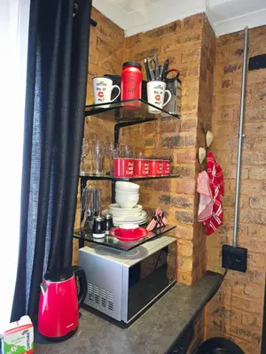 a kitchen with a microwave on a brick wall at The View in Pretoria