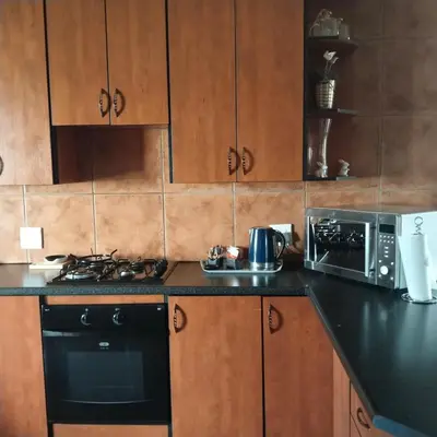 a kitchen with a stove top oven next to a microwave at Melkbos Place in Witbank