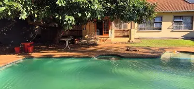 a large pool of water in front of a house at Tranquil, Home Away from Home in Pretoria