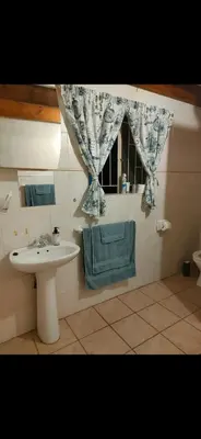 a bathroom with a sink and a window at Tranquil, Home Away from Home in Pretoria