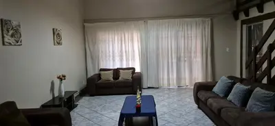 a living room with a couch and a table at Tranquil, Home Away from Home in Pretoria
