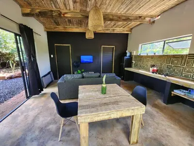 a living room with a table and a couch at Hartbeest Bush Stay #28 in Hartbeespoort