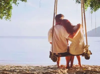 a man and woman sitting on a swing on the beach at Strong Spells To Fix Relationship Problem in Polokwane