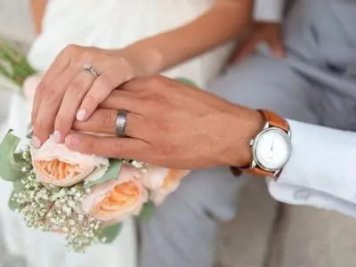 a bride and groom with their hands on a bouquet at Strong Spells To Fix Relationship Problem in Polokwane