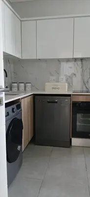 a kitchen with a dishwasher and a washer at Munyaka in Midrand