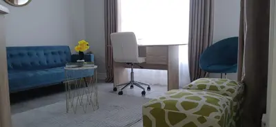 a living room with a blue couch and a chair at Munyaka in Midrand