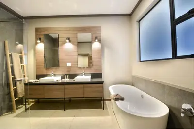 a bathroom with a sink and a toilet and a mirror at Zebula Golf Estate & Spa Executive Holiday Homes in Mabula
