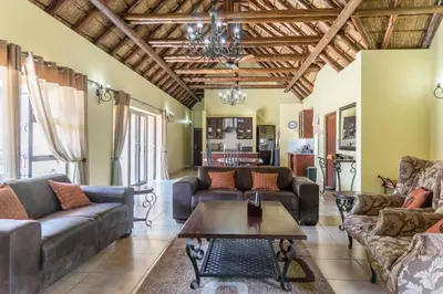 a living room with couches and a table at Zebula Golf Estate & Spa Executive Holiday Homes in Mabula