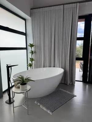 a white bath tub in a bathroom with windows at blydebushvilla in Hoedspruit