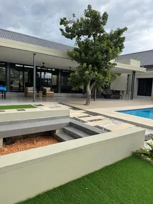 a building with a tree and a swimming pool at blydebushvilla in Hoedspruit