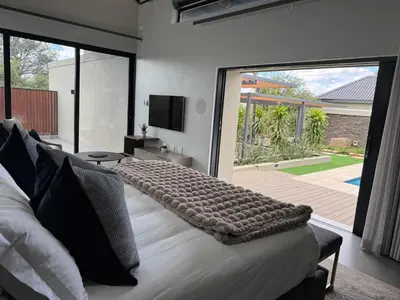 a bedroom with a bed and a large sliding glass door at blydebushvilla in Hoedspruit