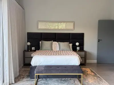 a bedroom with a large bed with a black headboard at blydebushvilla in Hoedspruit