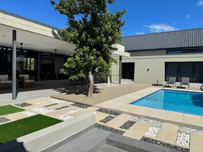 a house with a swimming pool and a tree at blydebushvilla in Hoedspruit