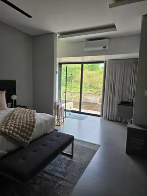 a bedroom with a bed and a couch and a window at blydebushvilla in Hoedspruit