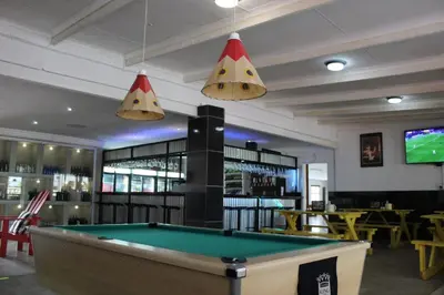 a pool table in a bar with two lights at Aurora Village in Polokwane