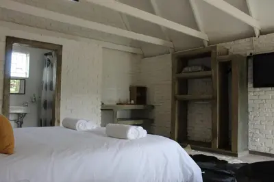 a bedroom with a white bed with towels on it at Aurora Village in Polokwane