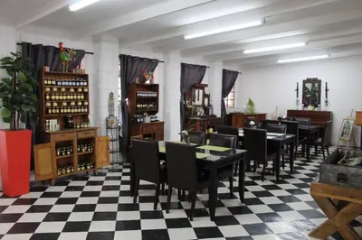 a restaurant with black tables and chairs on a checkered floor at Aurora Village in Polokwane