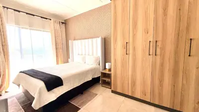 a bedroom with a bed and a large window at HeartWood Haven in Midrand