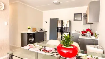a kitchen with a glass table with a red bowl on it at HeartWood Haven in Midrand