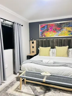 a bedroom with two beds and a painting on the wall at Tranquil Acres in Nelspruit