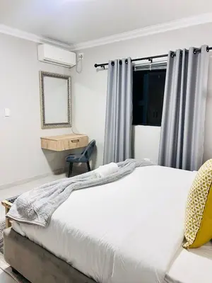a bedroom with a white bed and a chair at Tranquil Acres in Nelspruit