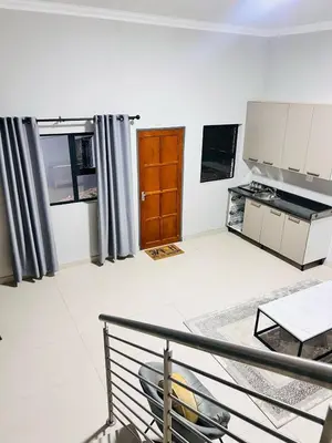 a living room with a kitchen and a table at Tranquil Acres in Nelspruit