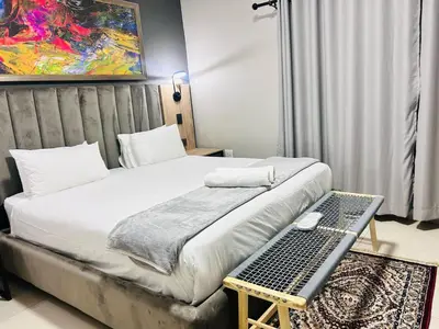 a bedroom with a bed and a table with a keyboard at Tranquil Acres in Nelspruit