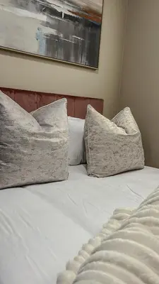 a bed with two pillows on top of it at The Ridge Modern Escape in Midrand