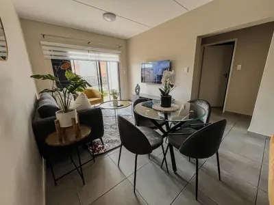 a living room with a table and chairs at The Ridge Modern Escape in Midrand