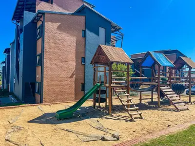a playground with a green slide and a swing set at The Ridge Modern Escape in Midrand