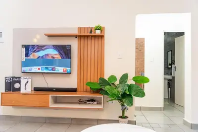 a living room with a tv on a wooden entertainment center at Palm Nest in Kempton Park
