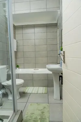 a bathroom with a tub and a sink and a toilet at Palm Nest in Kempton Park