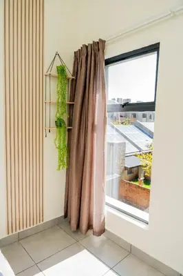 a room with a window with a curtain at Palm Nest in Kempton Park