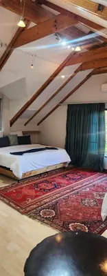 a bedroom with two beds and a rug on the floor at Brookyard Guest House in Pretoria