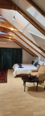a bedroom with a bed and a couch and a table at Brookyard Guest House in Pretoria