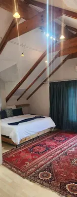 a bedroom with a bed and a rug on the floor at Brookyard Guest House in Pretoria