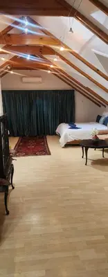 a attic room with a bed and a table at Brookyard Guest House in Pretoria