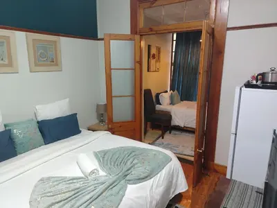 a bedroom with a bed and a room with a mirror at Brookyard Guest House in Pretoria