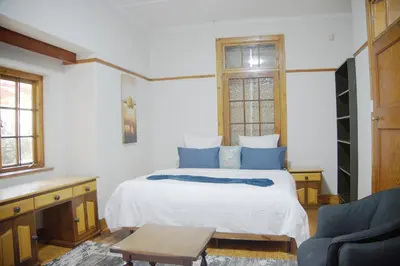 a bedroom with a white bed with blue pillows at Brookyard Guest House in Pretoria