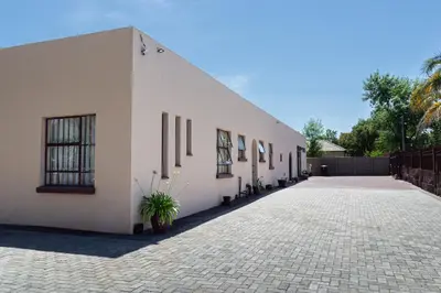 a large white building with a brick driveway at 18 Churchill Avenue in Witbank