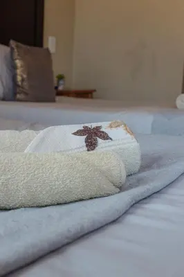 a towel laying on top of a bed at 18 Churchill Avenue in Witbank