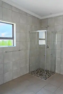 a shower with a glass door in a bathroom at 18 Churchill Avenue in Witbank